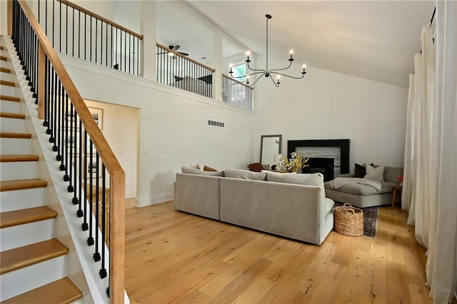 110 Cherokee Ln, Lake Winnebago, MO 64034 - living area with stairs, light wood-type flooring, high vaulted ceiling, a fireplace, and a ceiling fan