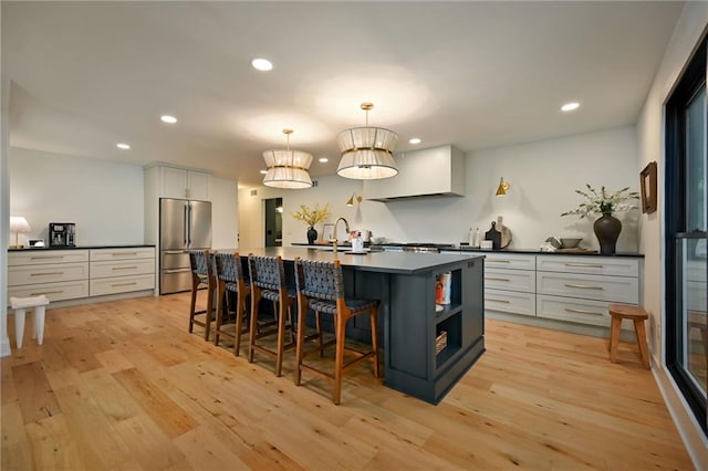 110 Cherokee Ln, Lake Winnebago, MO 64034 - kitchen featuring stainless steel refrigerator, light wood-type flooring, dark countertops, a sink, and recessed lighting