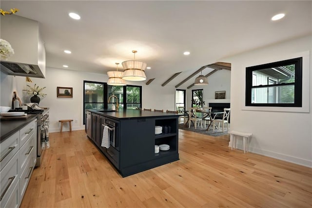 110 Cherokee Ln, Lake Winnebago, MO 64034 - kitchen with open shelves, dark countertops, wall chimney range hood, a sink, and light wood-style flooring