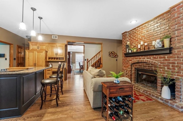 12806 Goddard Ave, Overland Park, KS 66213 - living area with light wood-style flooring, a fireplace, and stairs