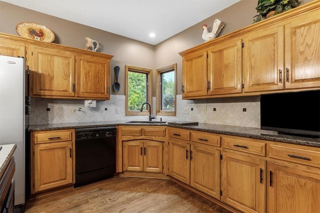 12806 Goddard Ave, Overland Park, KS 66213 - kitchen with black dishwasher, a sink, freestanding refrigerator, light wood-style flooring, and tasteful backsplash