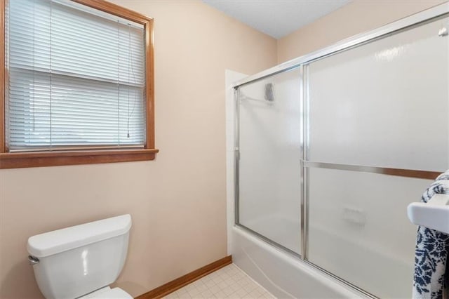 12806 Goddard Ave, Overland Park, KS 66213 - bathroom with toilet, shower / bath combination with glass door, baseboards, and tile patterned floors