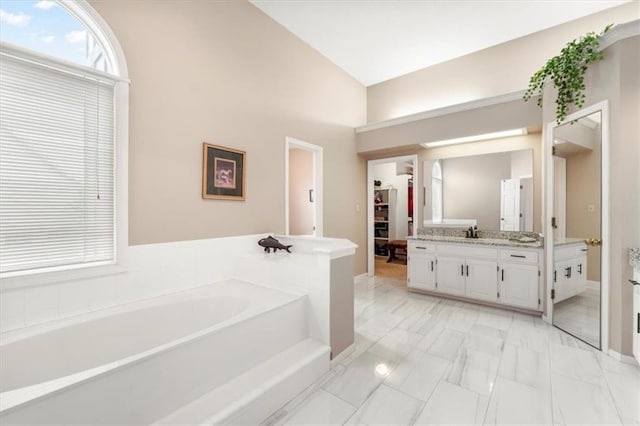 12806 Goddard Ave, Overland Park, KS 66213 - bathroom featuring vanity, a garden tub, marble finish flooring, and a spacious closet