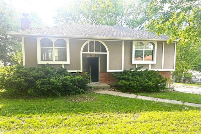 10636 N Grand Ave, Kansas City, MO 64155 - view of front facade with a chimney, a front lawn, brick siding, and stucco siding