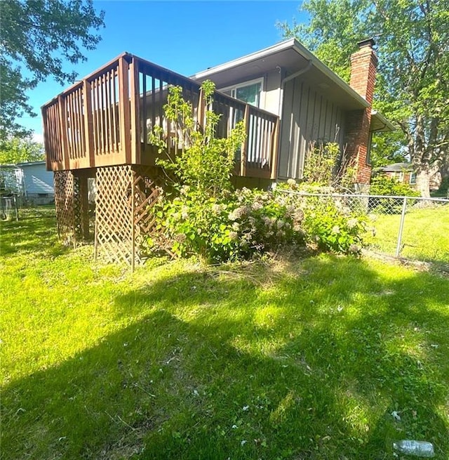 10636 N Grand Ave, Kansas City, MO 64155 - view of side of home with a chimney, a deck, and board and batten siding
