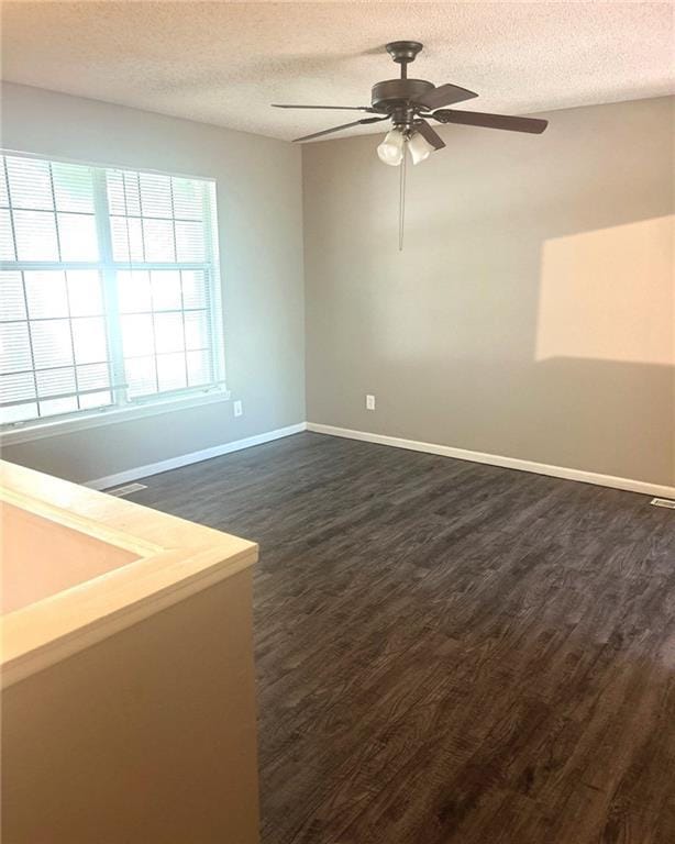 10636 N Grand Ave, Kansas City, MO 64155 - spare room with dark wood-style floors, a ceiling fan, baseboards, and a textured ceiling