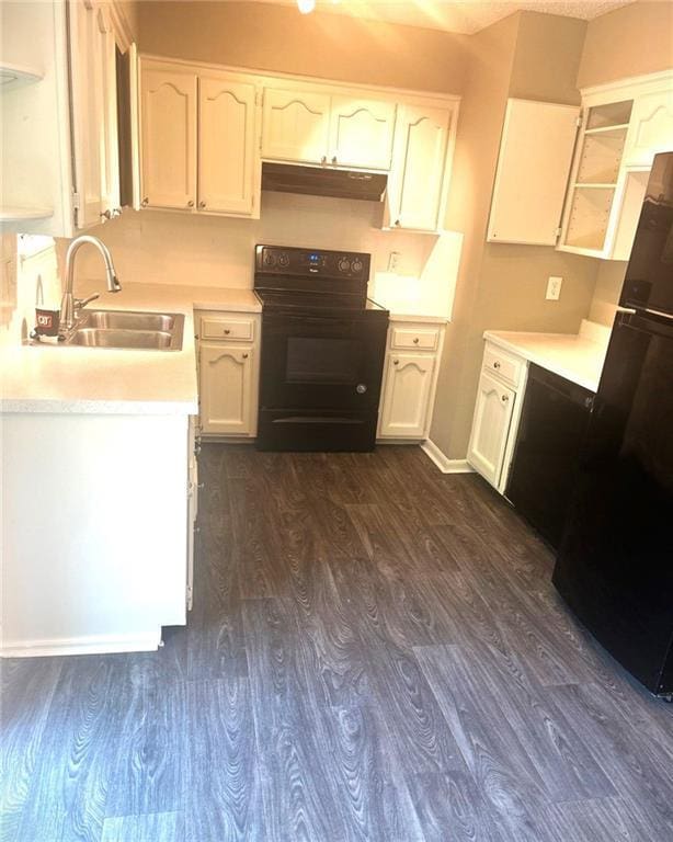 10636 N Grand Ave, Kansas City, MO 64155 - kitchen with black appliances, under cabinet range hood, a sink, and dark wood-style floors