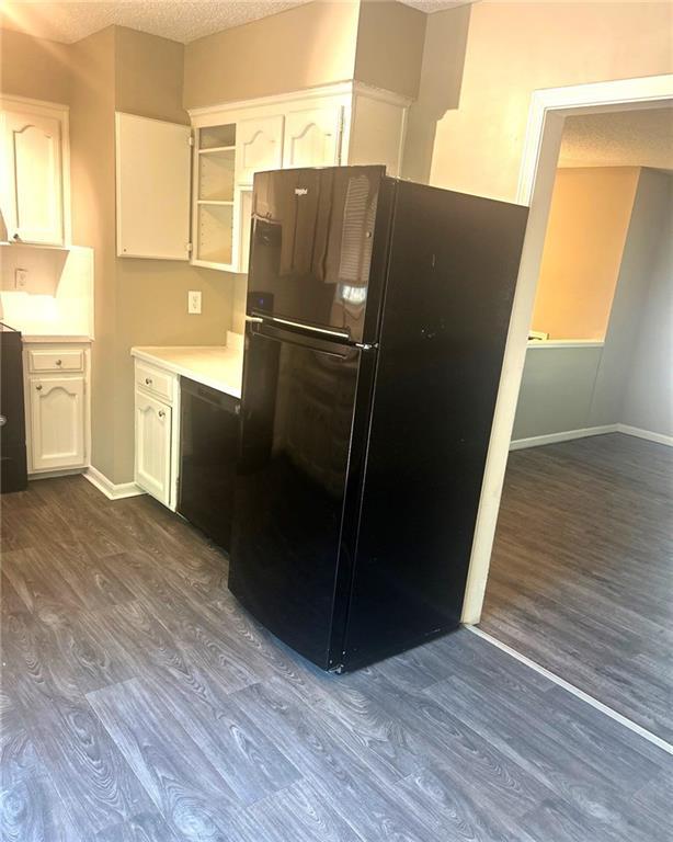 10636 N Grand Ave, Kansas City, MO 64155 - kitchen featuring freestanding refrigerator, dark wood-style floors, white cabinets, light countertops, and a textured ceiling