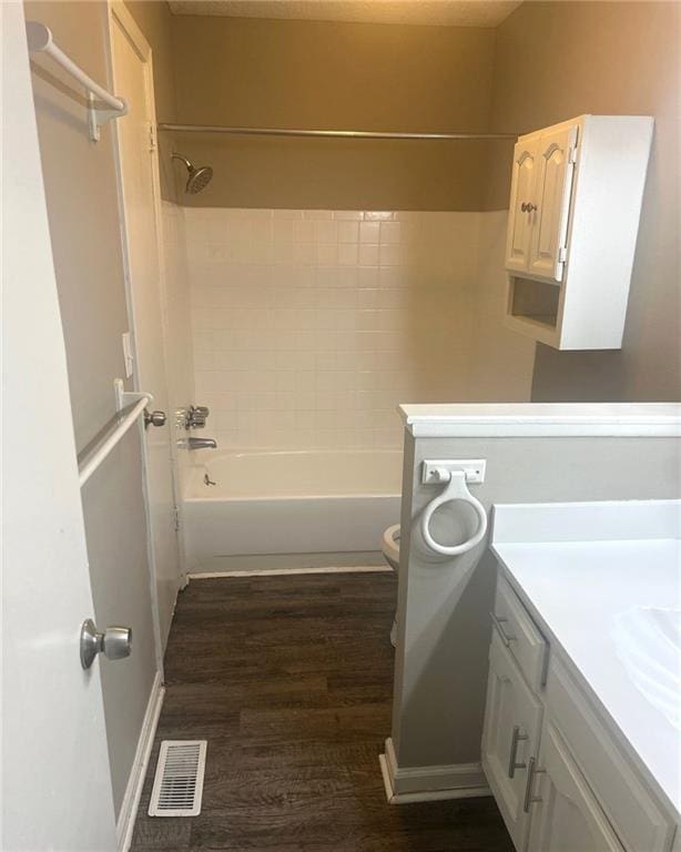 10636 N Grand Ave, Kansas City, MO 64155 - full bathroom featuring vanity, wood finished floors, toilet, and washtub / shower combination