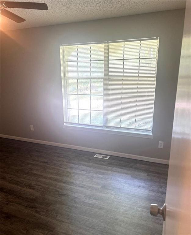10636 N Grand Ave, Kansas City, MO 64155 - empty room featuring ceiling fan, dark wood-style floors, baseboards, and a textured ceiling