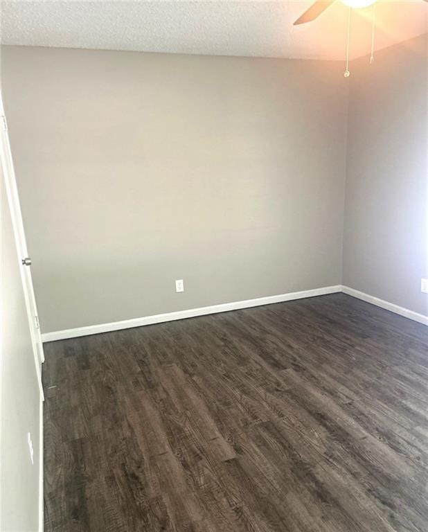 10636 N Grand Ave, Kansas City, MO 64155 - spare room featuring dark wood-style floors, baseboards, a ceiling fan, and a textured ceiling