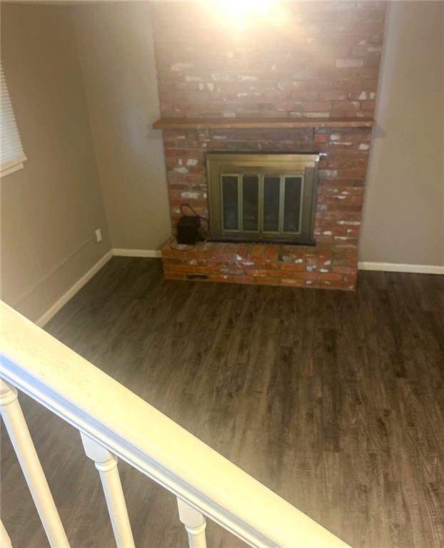 10636 N Grand Ave, Kansas City, MO 64155 - detailed view of wood finished floors, baseboards, and a fireplace