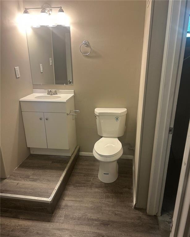 10636 N Grand Ave, Kansas City, MO 64155 - half bathroom with vanity, toilet, wood finished floors, and baseboards