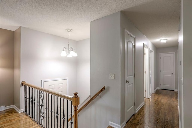 606 W Smith St, Spring Hill, KS 66083 - hallway featuring an upstairs landing, wood finished floors, a chandelier, and a textured ceiling