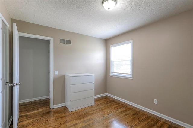 606 W Smith St, Spring Hill, KS 66083 - empty room with wood finished floors and a textured ceiling
