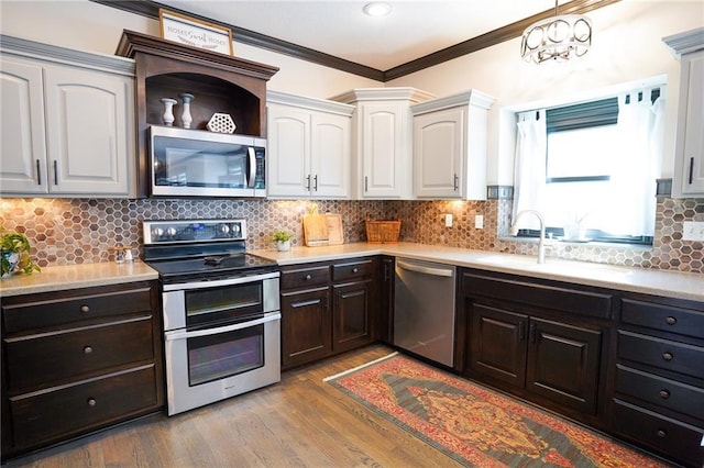 3832 SW Boulder Dr, Lees Summit, MO 64082 - kitchen featuring appliances with stainless steel finishes, ornamental molding, light countertops, light wood finished floors, and tasteful backsplash