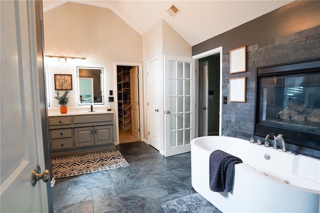 3832 SW Boulder Dr, Lees Summit, MO 64082 - bathroom featuring a freestanding bath, vaulted ceiling, and vanity