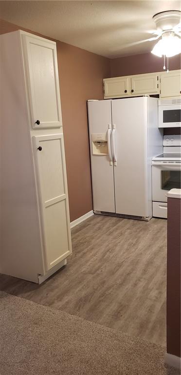 306 Morningside Dr, Richmond, MO 64085 - kitchen with white appliances, white cabinetry, ceiling fan, and light wood finished floors