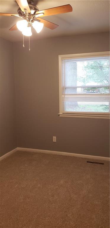 306 Morningside Dr, Richmond, MO 64085 - carpeted empty room featuring baseboards and a ceiling fan