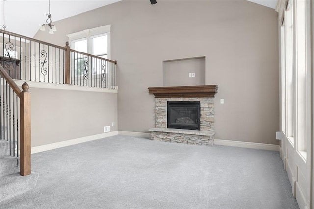 486 S 137th Pl, Bonner Springs, KS 66012 - unfurnished living room with carpet floors, baseboards, high vaulted ceiling, and a stone fireplace