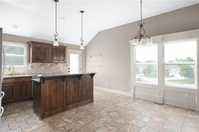 486 S 137th Pl, Bonner Springs, KS 66012 - kitchen with vaulted ceiling, tasteful backsplash, baseboards, dark brown cabinetry, and light stone finish flooring