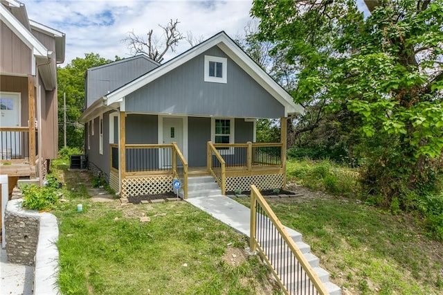 4233 Euclid Ave, Kansas City, MO 64130 - view of front of home featuring a porch, a front yard, and cooling unit