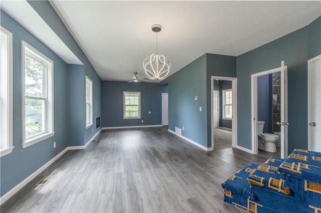 4233 Euclid Ave, Kansas City, MO 64130 - unfurnished bedroom with a chandelier, wood finished floors, and baseboards