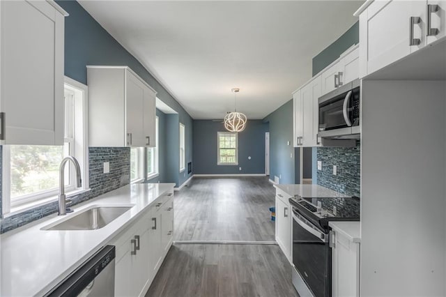 4233 Euclid Ave, Kansas City, MO 64130 - kitchen featuring appliances with stainless steel finishes, a sink, tasteful backsplash, and light countertops