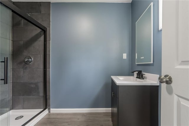 4233 Euclid Ave, Kansas City, MO 64130 - full bath with vanity, baseboards, a stall shower, and wood finished floors