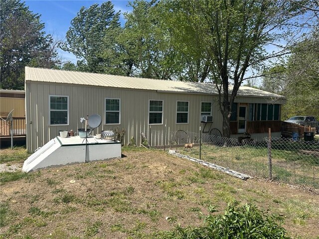 63 Clark Rd, Mapleton, KS 66754 - back of house featuring a sunroom, cooling unit, board and batten siding, and metal roof