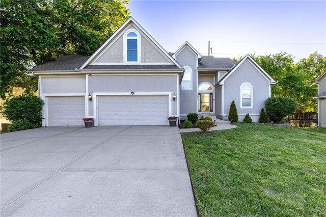 5916 NE Turquoise Dr, Lees Summit, MO 64064 - traditional-style house with an attached garage, concrete driveway, stucco siding, and a front lawn