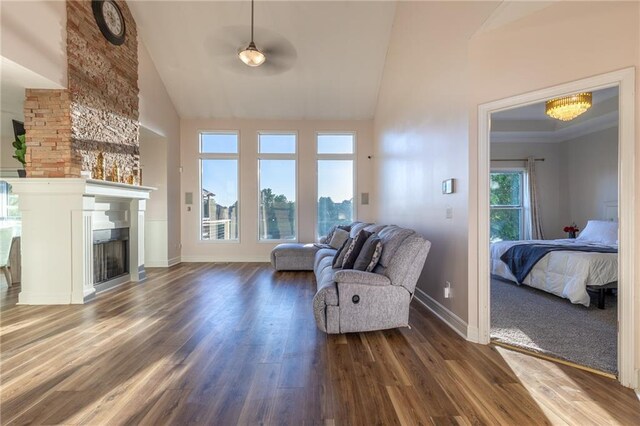 5916 NE Turquoise Dr, Lees Summit, MO 64064 - living area with high vaulted ceiling, dark wood-style flooring, baseboards, a fireplace, and a ceiling fan