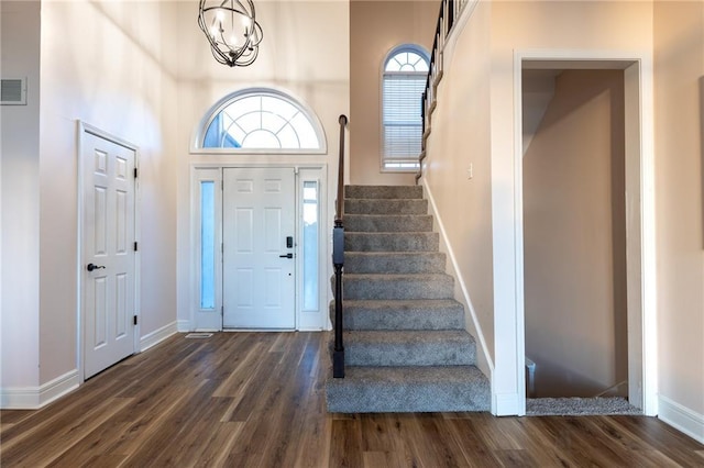 5916 NE Turquoise Dr, Lees Summit, MO 64064 - entryway with a chandelier, dark wood-style flooring, stairs, baseboards, and a towering ceiling