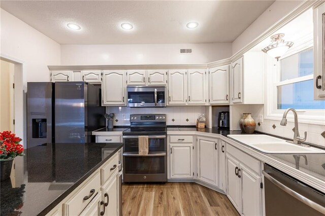 5916 NE Turquoise Dr, Lees Summit, MO 64064 - kitchen featuring stainless steel appliances, a sink, white cabinets, tasteful backsplash, and recessed lighting