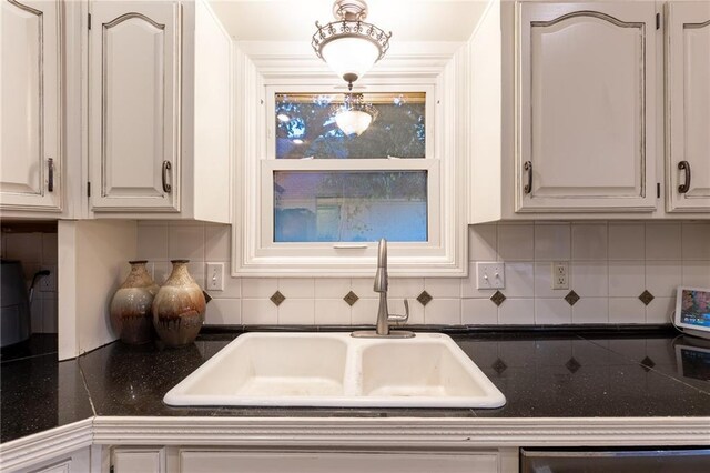 5916 NE Turquoise Dr, Lees Summit, MO 64064 - kitchen with a sink, dishwasher, dark countertops, backsplash, and white cabinets