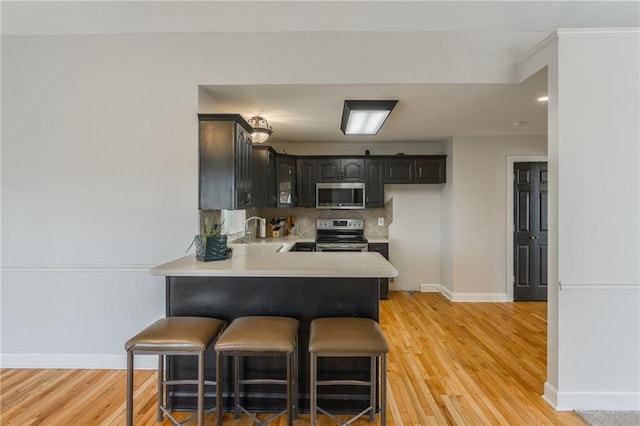1955 Birmingham Rd, Liberty, MO 64068 - kitchen with stainless steel appliances, a peninsula, light wood-style floors, and light countertops