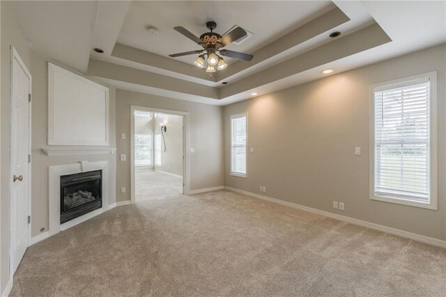 1955 Birmingham Rd, Liberty, MO 64068 - unfurnished living room featuring ceiling fan, a raised ceiling, light carpet, a glass covered fireplace, and recessed lighting