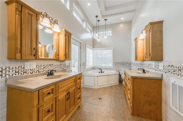 1955 Birmingham Rd, Liberty, MO 64068 - bathroom featuring two vanities, tile patterned flooring, a high ceiling, a bath, and plenty of natural light