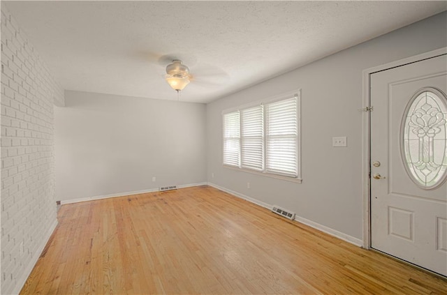 2917 N 83rd Ter, Kansas City, KS 66109 - entryway featuring light wood finished floors, ceiling fan, brick wall, baseboards, and a textured ceiling