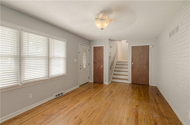 2917 N 83rd Ter, Kansas City, KS 66109 - entryway with stairway, light wood finished floors, brick wall, a ceiling fan, and baseboards