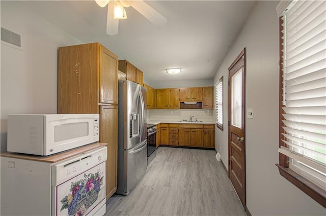 2917 N 83rd Ter, Kansas City, KS 66109 - kitchen featuring appliances with stainless steel finishes, a sink, light wood-style flooring, brown cabinets, and a ceiling fan