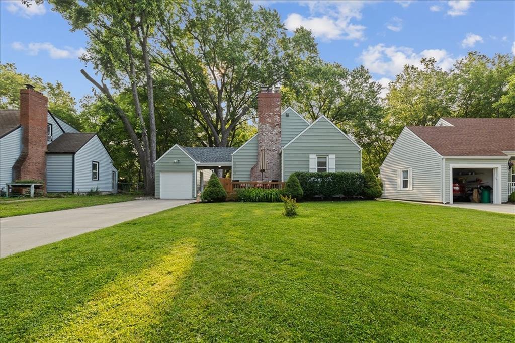 5315 Walmer St, Mission, KS 66202 - view of front of property with a garage, a front yard, a chimney, and driveway
