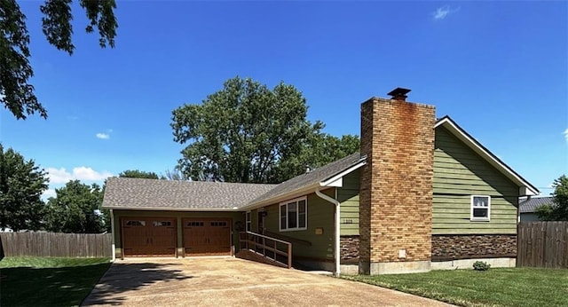 1205 W 14th Street Ct, Chanute, KS 66720 - view of side of property with an attached garage, a chimney, and concrete driveway
