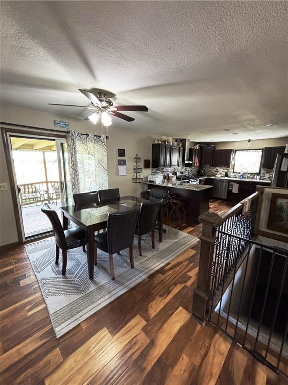 1205 W 14th Street Ct, Chanute, KS 66720 - dining area with dark wood-style flooring, a textured ceiling, and a ceiling fan