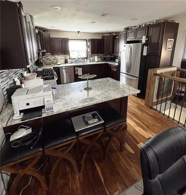 1205 W 14th Street Ct, Chanute, KS 66720 - kitchen featuring stainless steel appliances, a peninsula, dark brown cabinets, and a sink