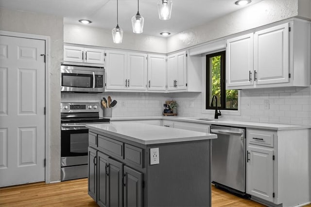 9327 Tomashaw Ln, Lenexa, KS 66219 - kitchen with appliances with stainless steel finishes, white cabinetry, light countertops, and tasteful backsplash