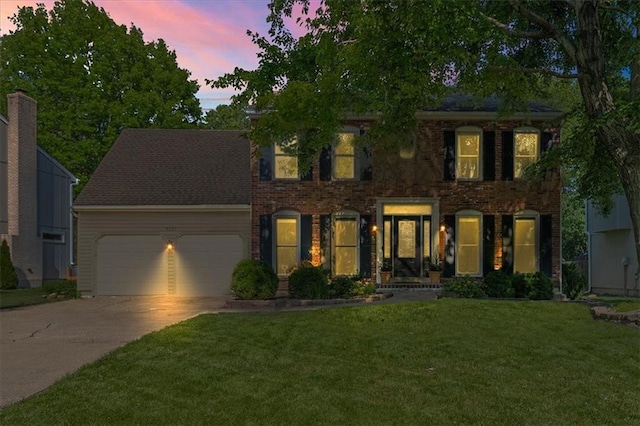 9327 Tomashaw Ln, Lenexa, KS 66219 - view of front of property with a garage, driveway, a lawn, and brick siding
