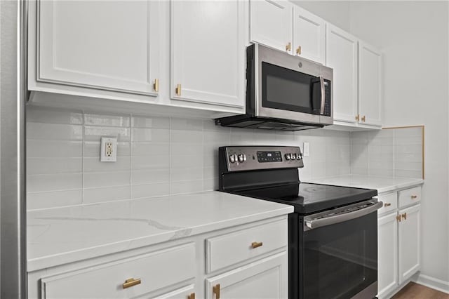 1932 N 80th Ct, Kansas City, KS 66112 - kitchen featuring appliances with stainless steel finishes, white cabinetry, decorative backsplash, and light stone counters