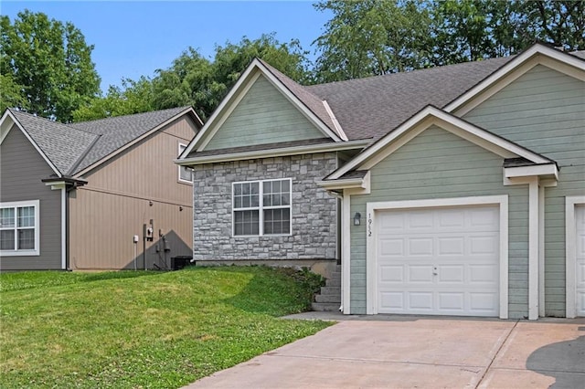 1932 N 80th Ct, Kansas City, KS 66112 - view of front of property featuring concrete driveway, a front yard, a garage, stone siding, and roof with shingles