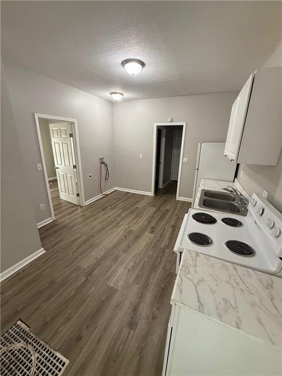3318 E 24th St, Kansas City, MO 64127 - kitchen with white appliances, baseboards, light countertops, and a textured ceiling